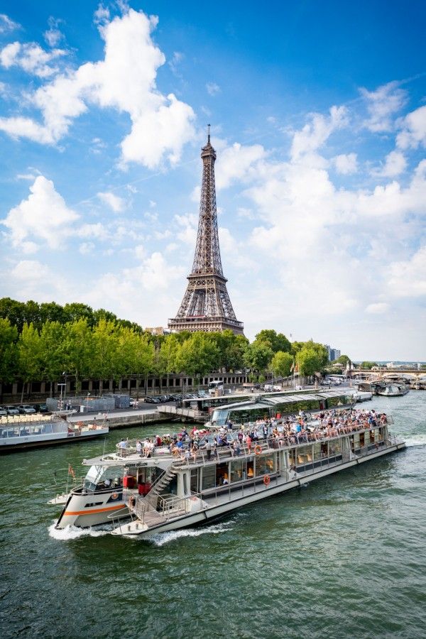 Barco de crucero navegando el Sena frente a la Torre Eiffel